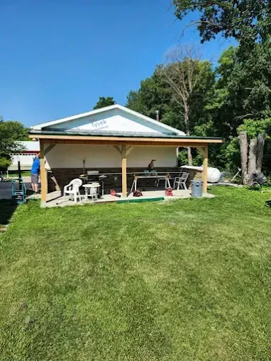 Covered patio addition with timber posts behind a home